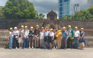 Large tour group photo outdoors with a scenic mountain backdrop