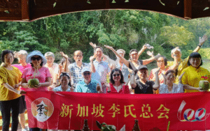 Tour group photo with a Chinese community association event banner