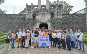 Tour group photo in front of a heritage stone church in the Philippines