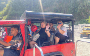 Tourists riding a red jeepney during a Philippine city tour