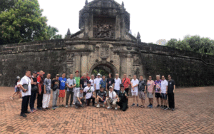 Tour group photo in front of a heritage stone fort in the Philippines